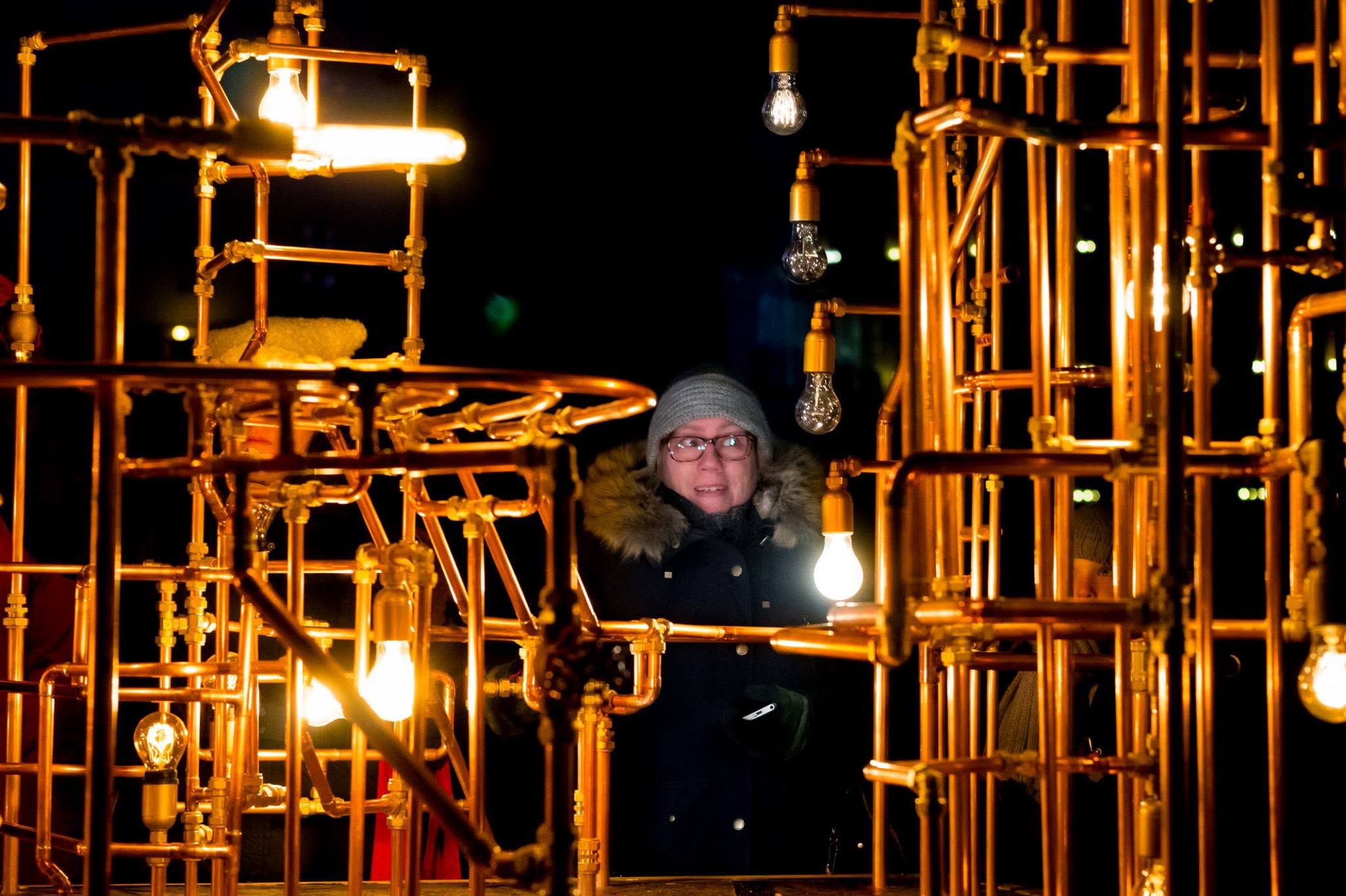 Copper pipe light sculpture at night