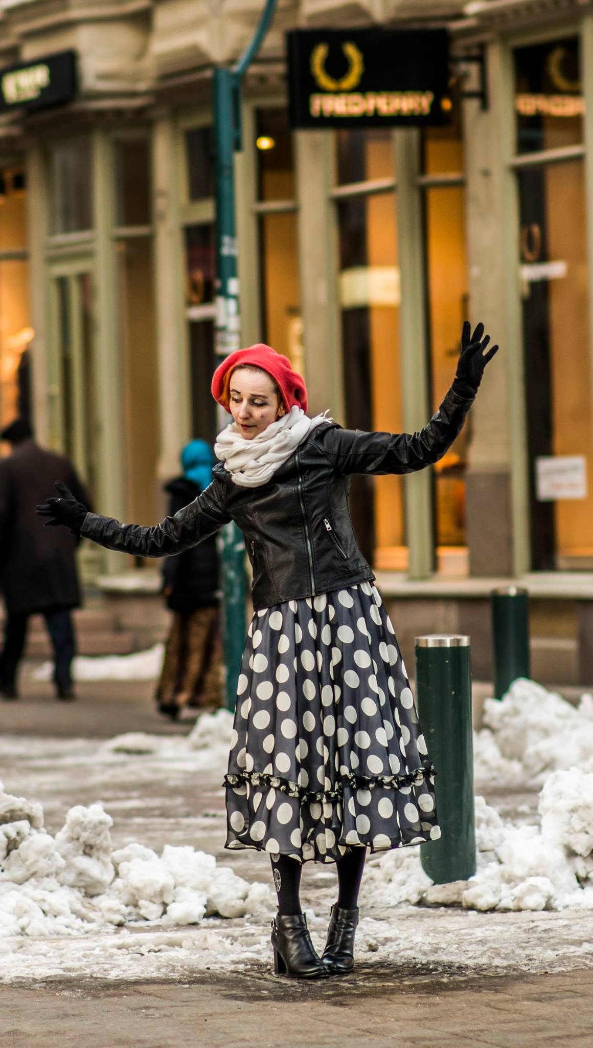 Woman in red beret dancing on snowy street