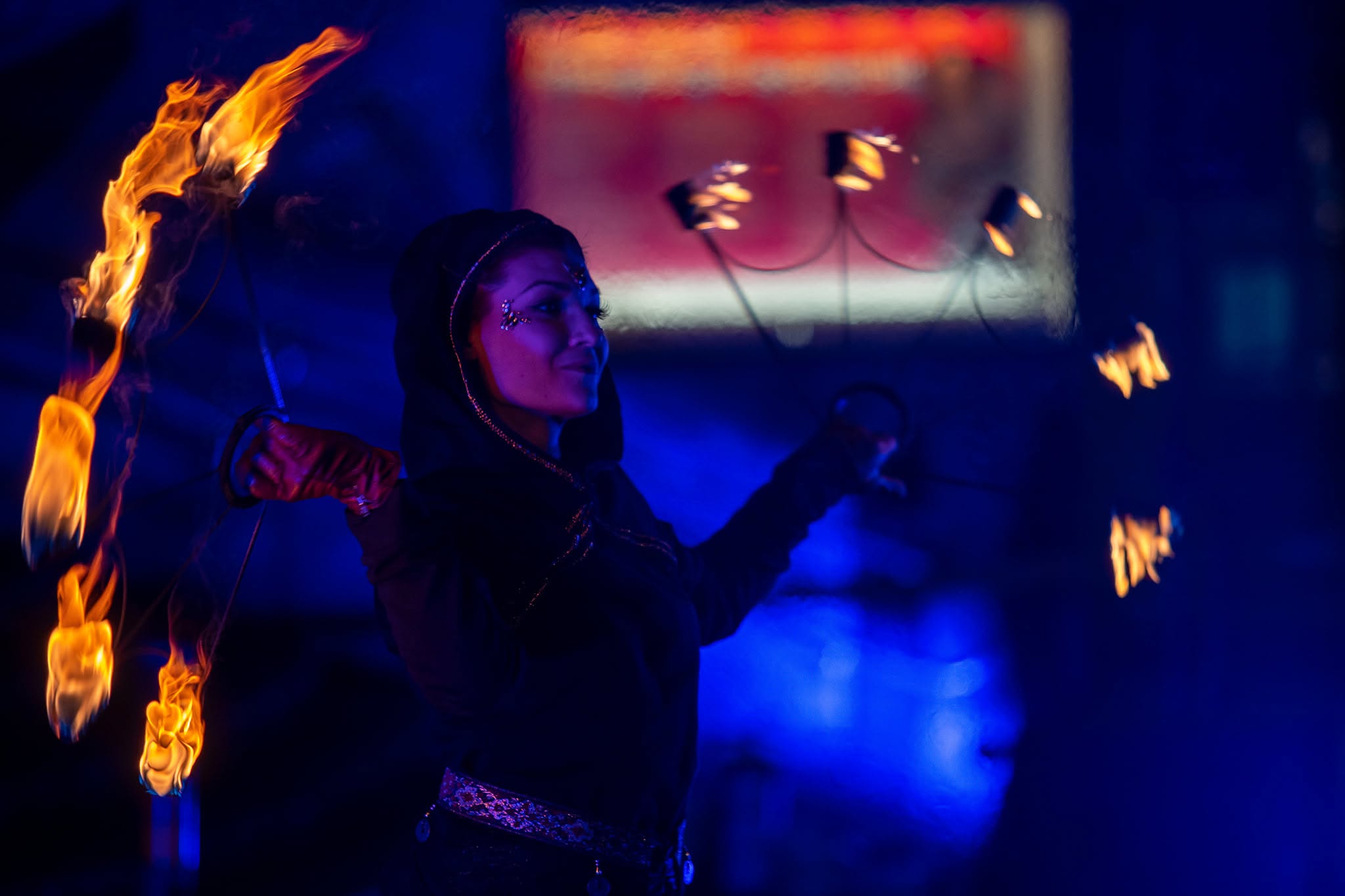 Fire performer with fan and staff
