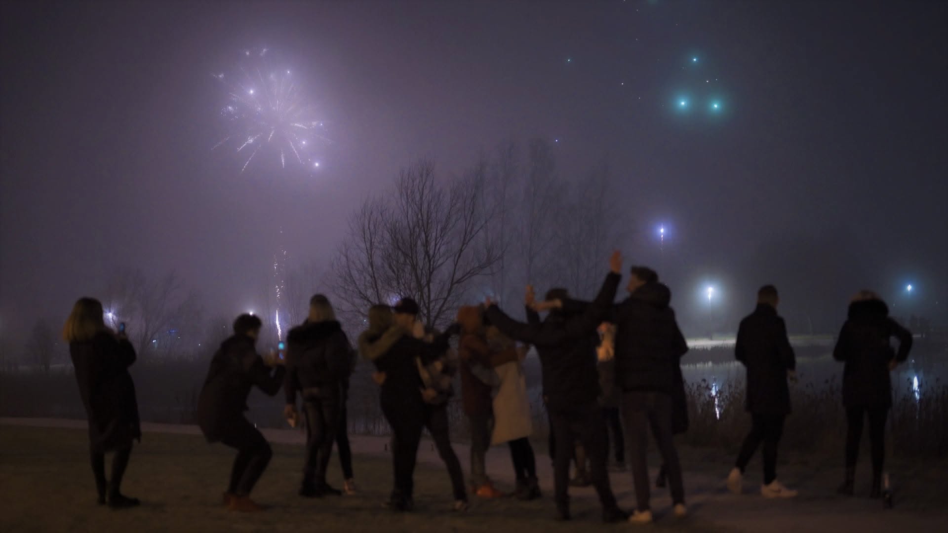 Fireworks and drone lights over a crowd