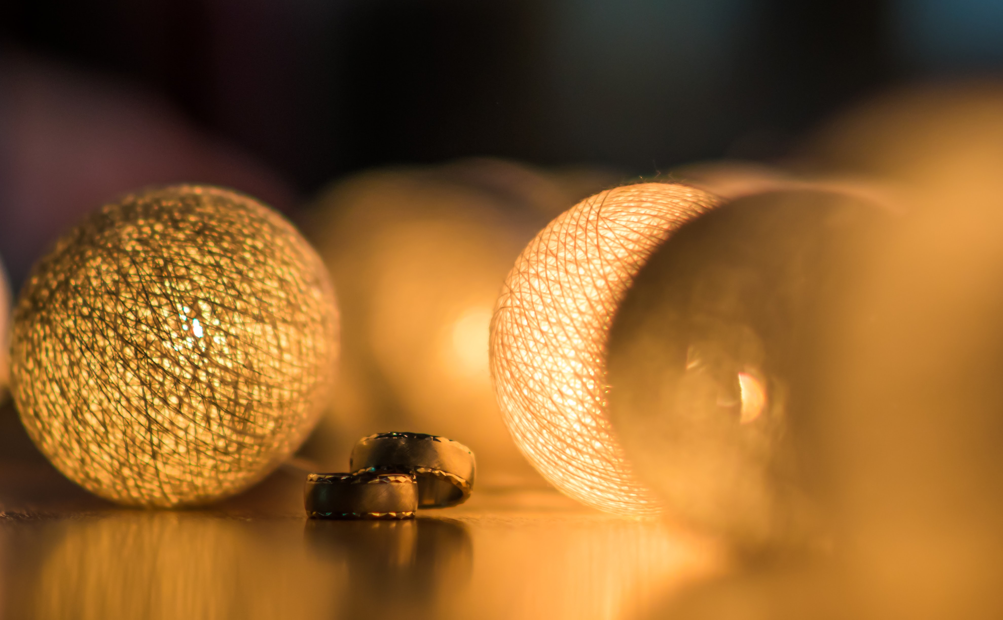 Wedding rings glowing under warm bokeh lights