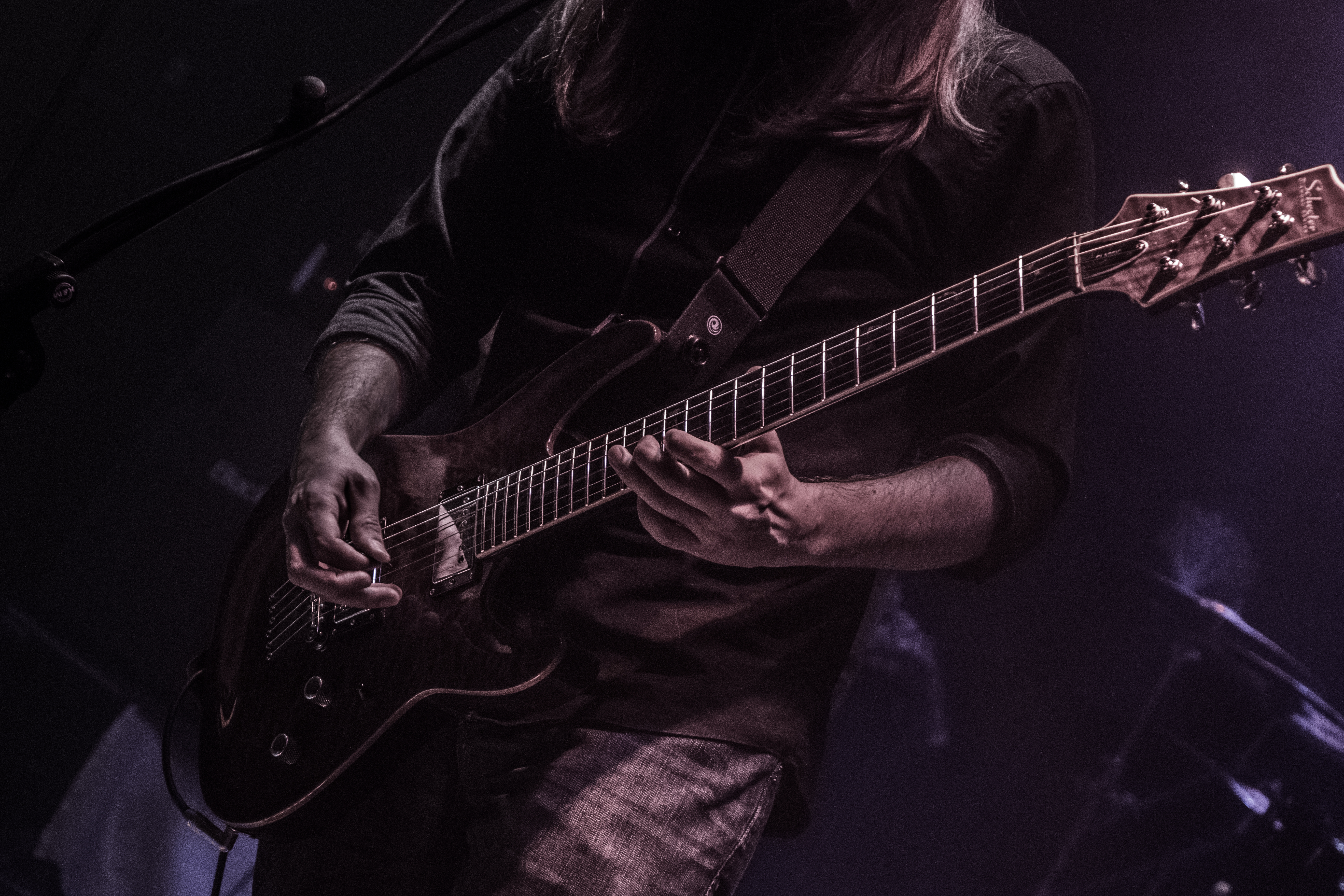 Guitarist hands under deep purple stage light
