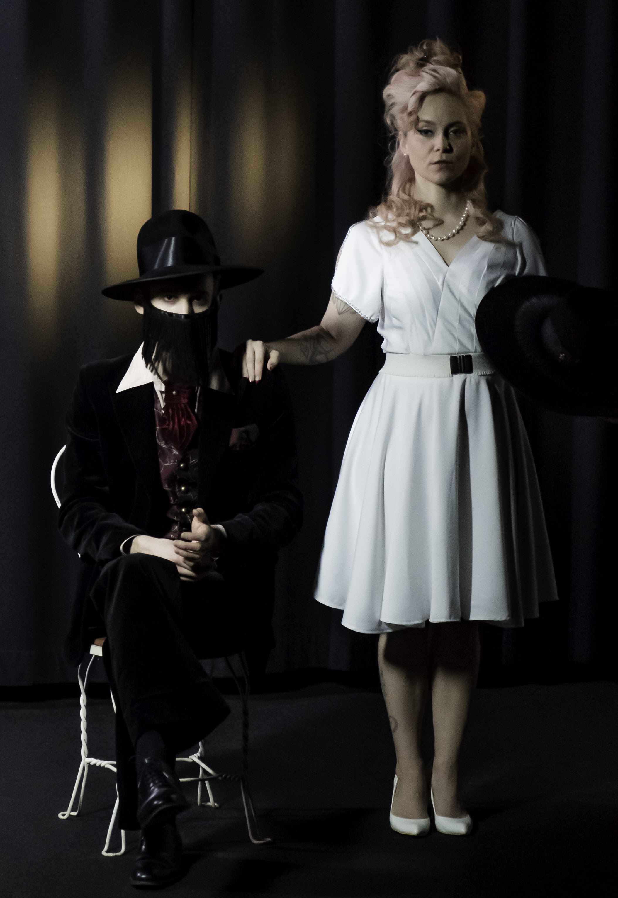 Theatrical noir portrait — man in fedora, woman in white dress